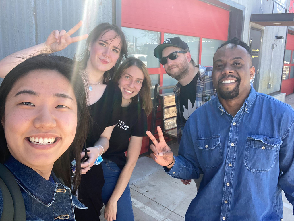 5 people outside of a BBQ restaurant taking a selfie
